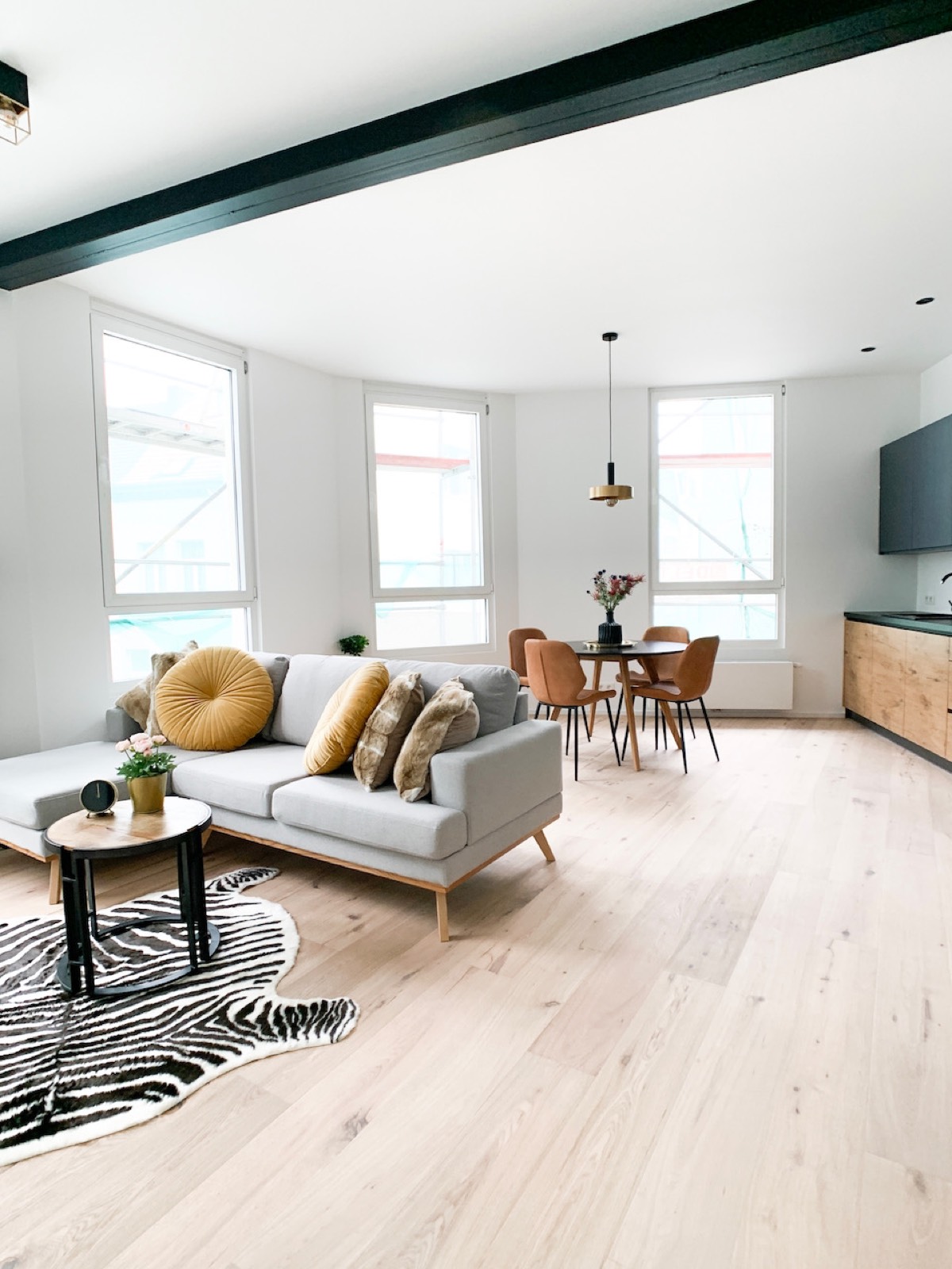 Open leefruimte met gele sofa in een gesplitst Antwerps stadspand na renovatie