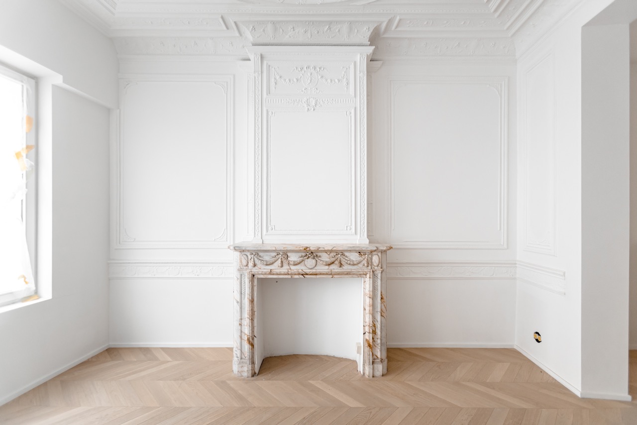 Marmeren schouw met klassieke wandmoluren in een gerestaureerd Antwerps herenhuis