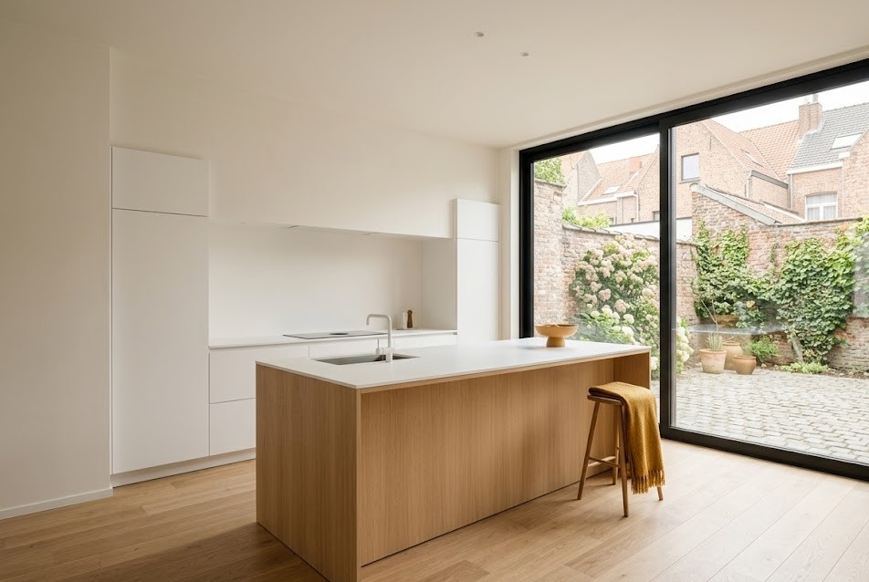 Open keuken met eiland in een gerenoveerd Antwerps appartement, illustratief bij vastgoedportefeuillestrategie